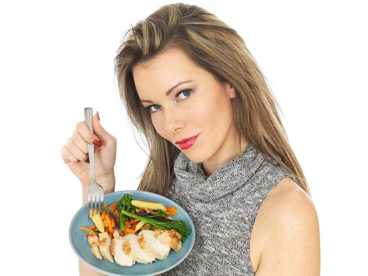 cô gái ăn thịt gà với rau để giảm cân